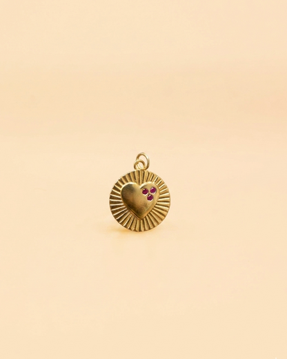 Gold pendant with a heart design on a beige background